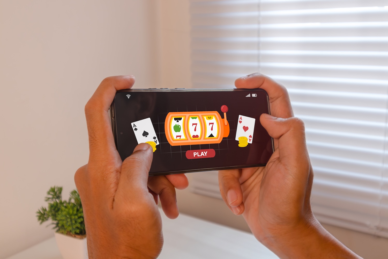 Man playing online casino gambling on a mobile phone to represent Gambling Debt Help