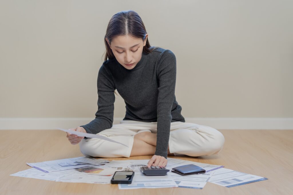 A woman looking at her expenses, bills and debt wondering how to get an IVA