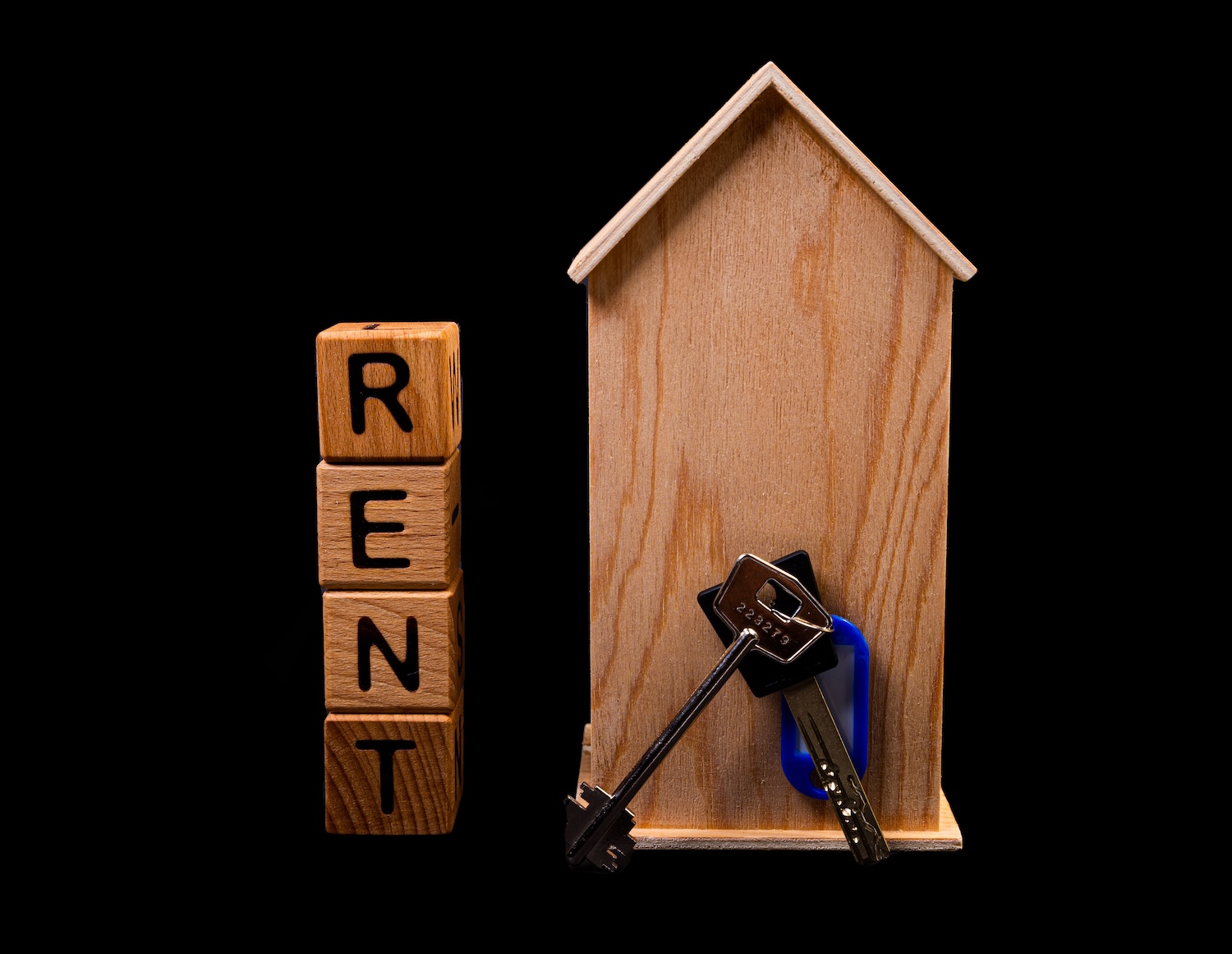 Wooden model house and keys illustrating help with rent arrears